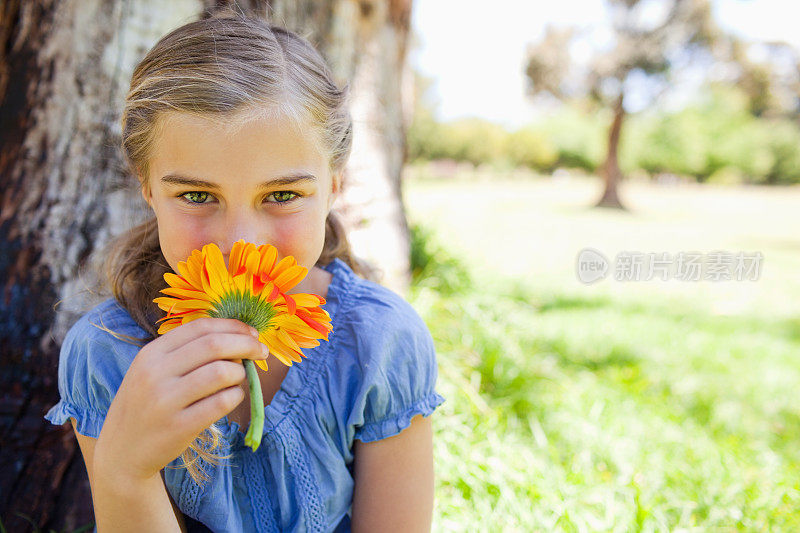 近距离的女孩闻着一朵漂亮的花