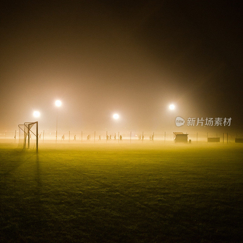 足球场在迷雾中被灯光包围