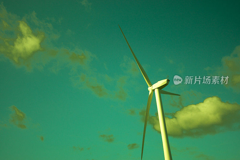 风力涡轮机映衬着绿色的天空