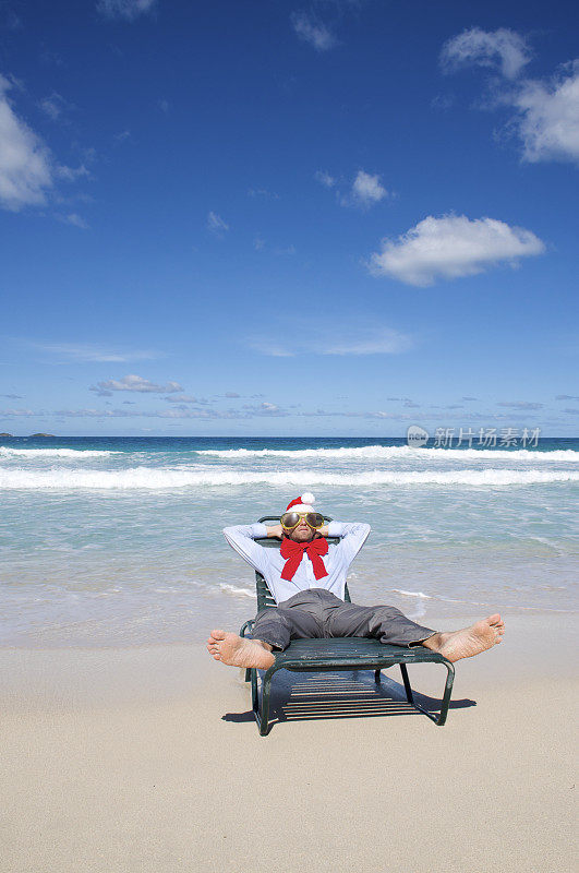 赤脚商人在沙滩椅上的圣诞老人帽上休息