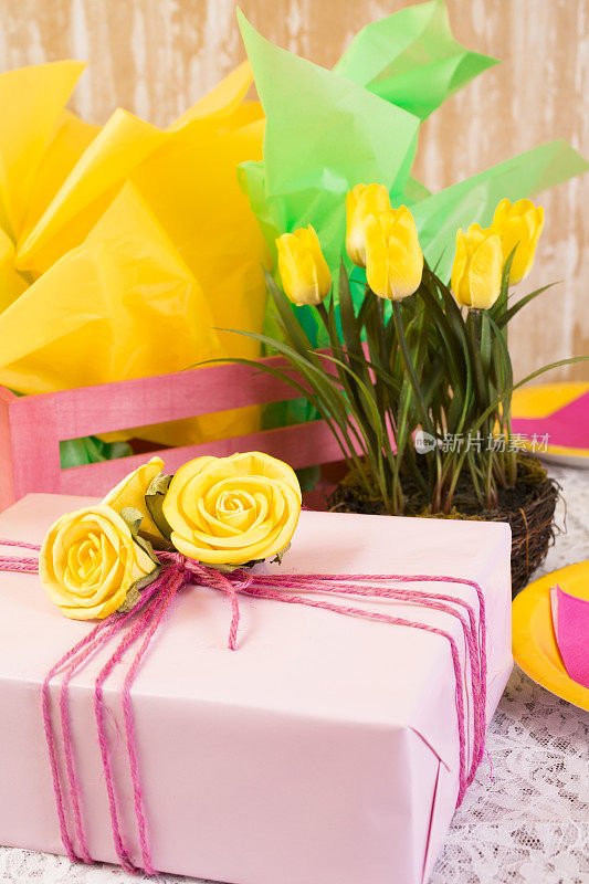 派对时间!黄色的花，礼物，餐桌上的盘子。女性化。