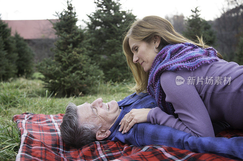 浪漫的成熟夫妇躺在野餐毯上