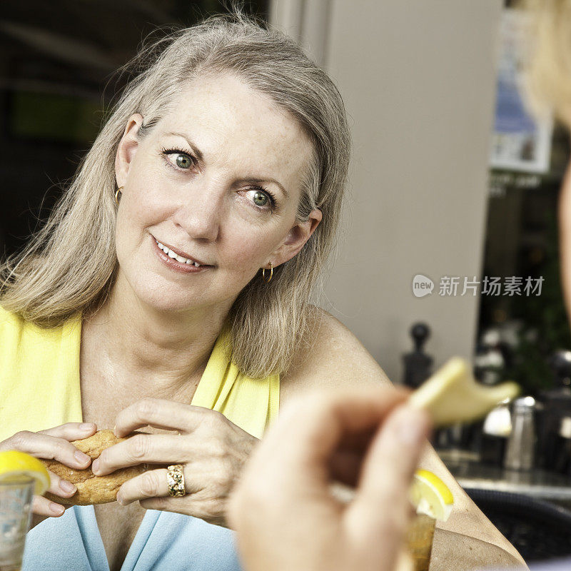 成熟的女人在餐厅和朋友吃午餐