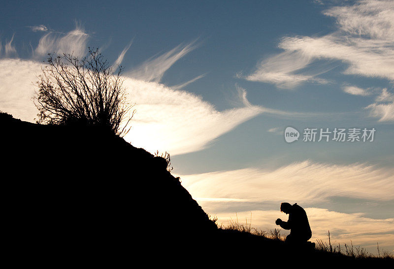 一个男人在外面祈祷的剪影