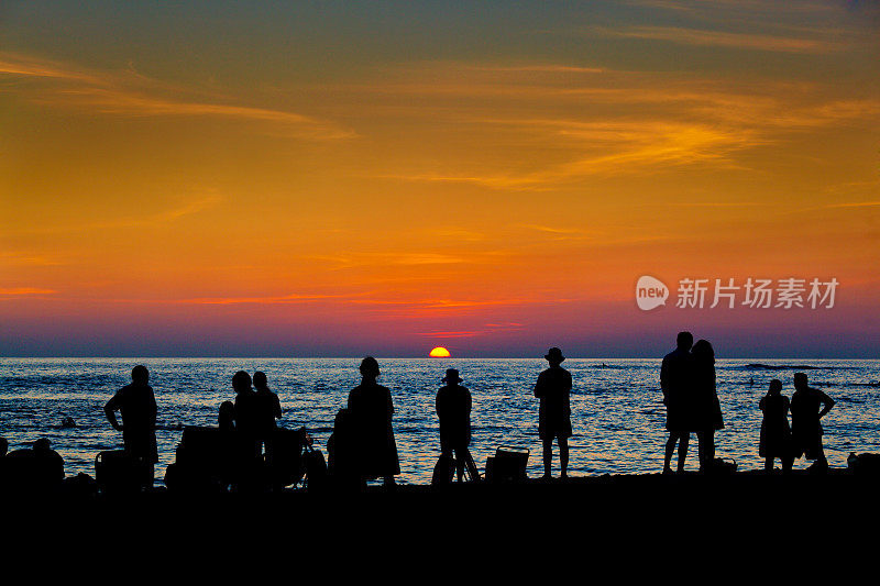 游客在夏威夷考艾岛的海滩上欣赏日落