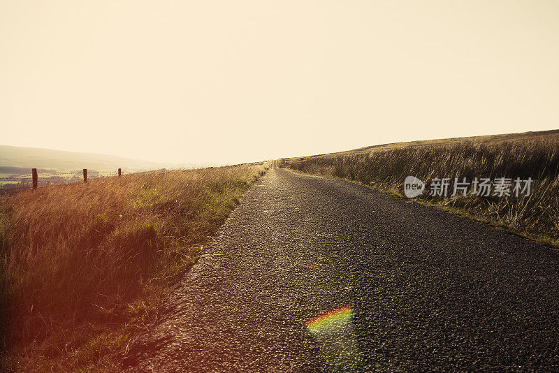 空旷的乡村道路在日落与镜头光晕