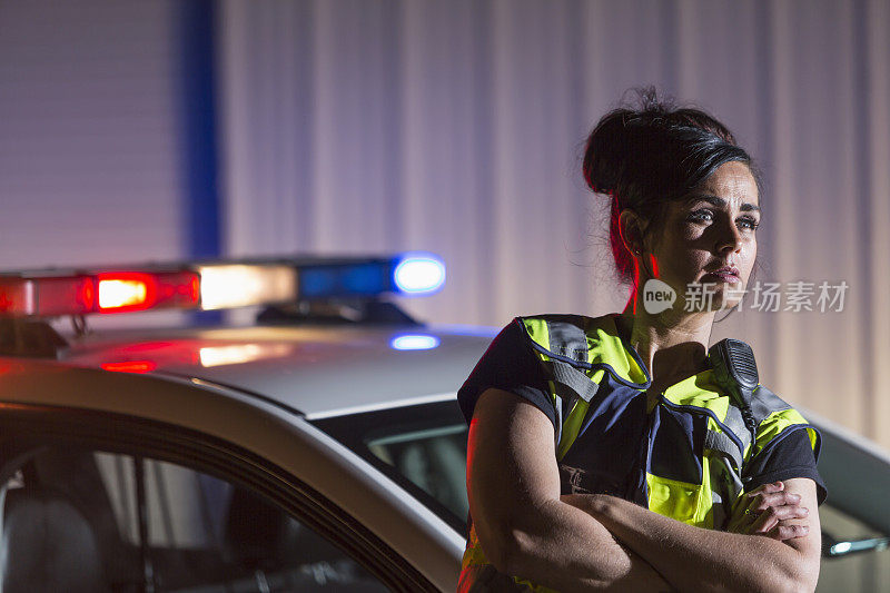 女警察晚上站在警车旁边