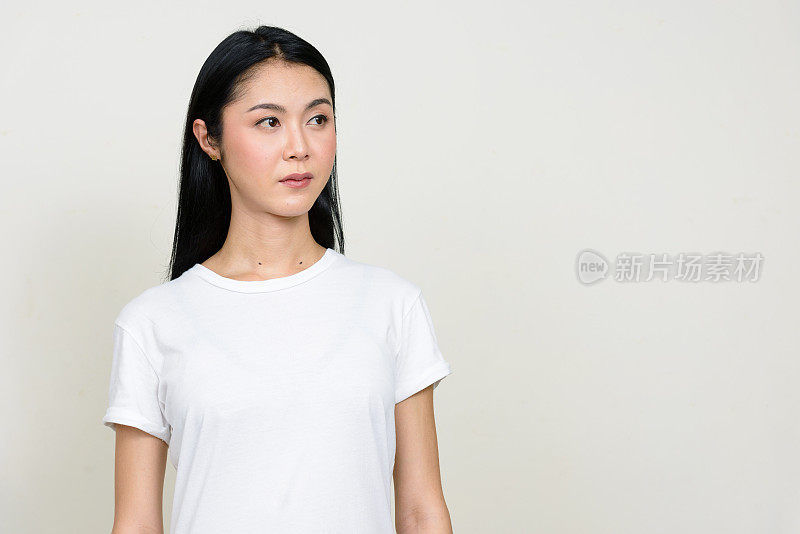 年轻美丽的亚洲女人穿着白色衬衫对抗白色背景