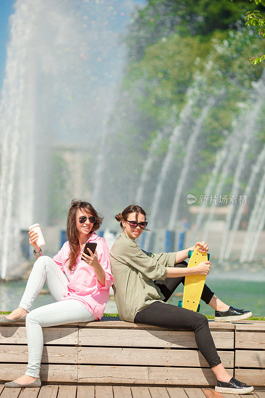 欧洲城市里快乐的年轻都市女孩的肖像。白人游客在户外玩滑板的大喷泉的背景下