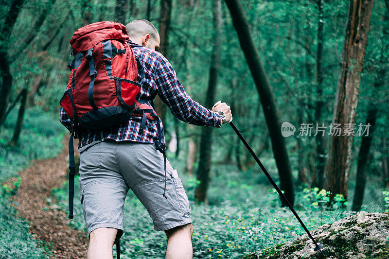 一个徒步旅行者正在用他的徒步手杖上山