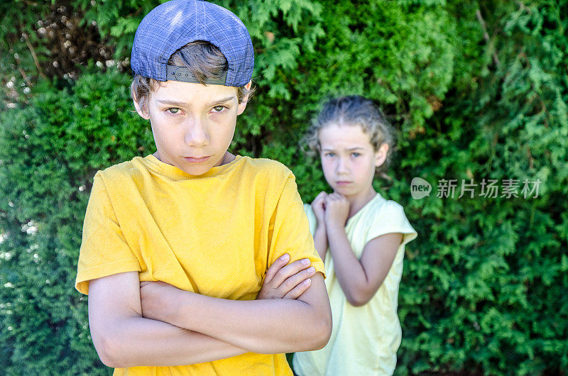 夏日里，一个小男孩站在妹妹面前保护她