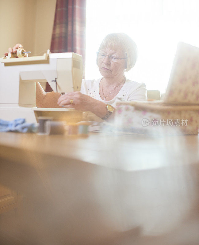 年长妇女准备缝纫机