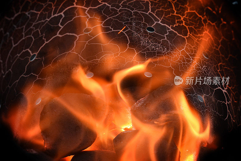 燃烧木炭团与红色火焰在烧烤烟囱的启动器，火的背景与复制空间
