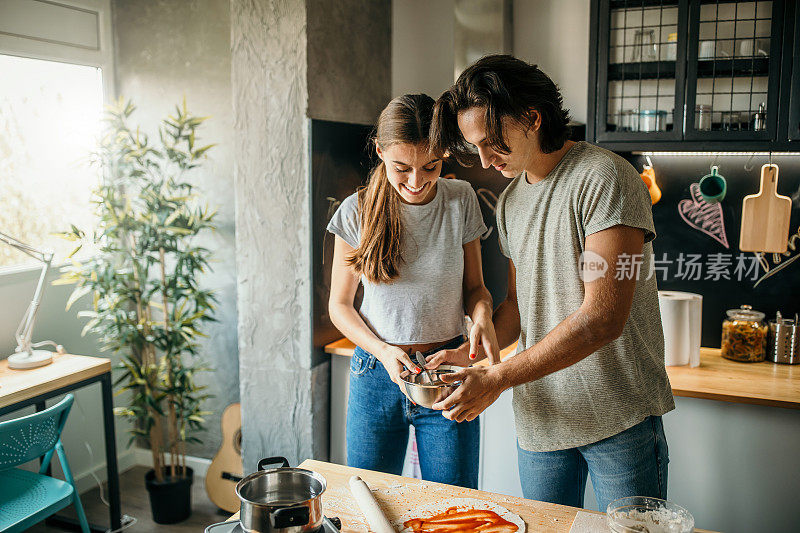 年轻夫妇在家里准备披萨