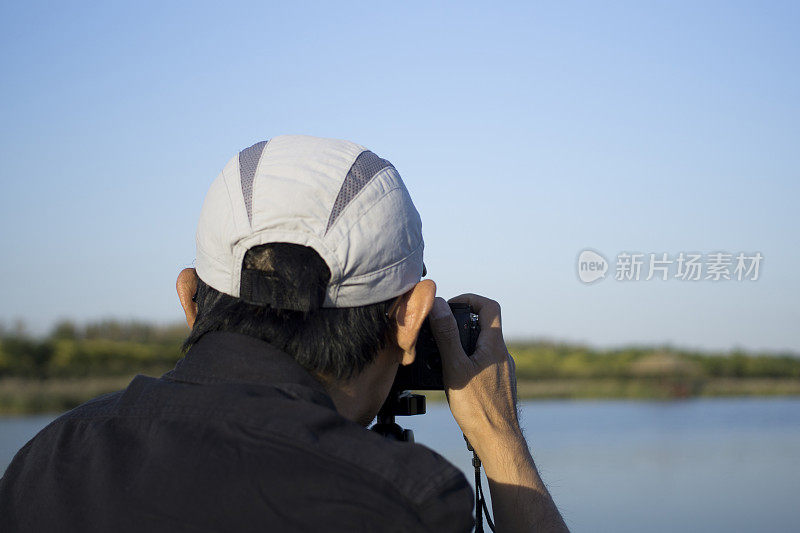 一名男子在湿地用相机拍照