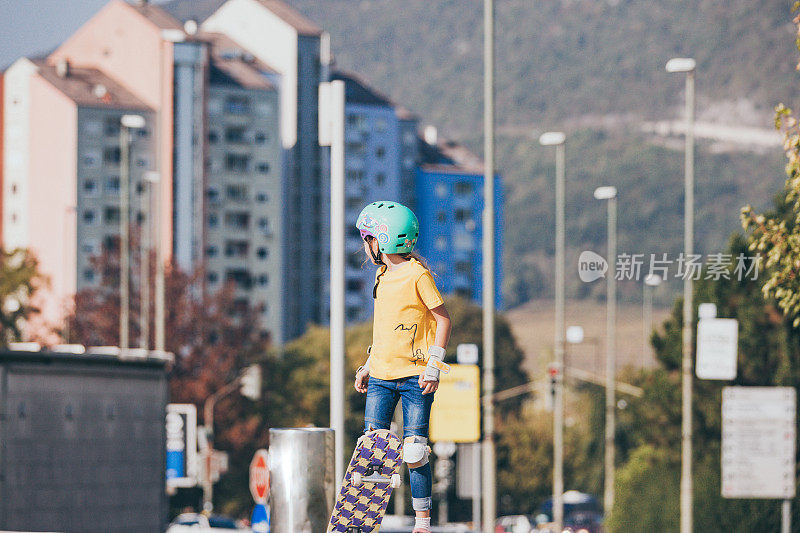 年轻的滑板女孩在一个城市