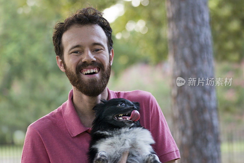 一个年轻人带着一只茨格斯皮兹博美犬