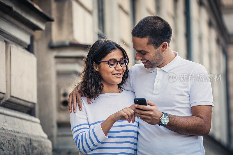 情侣在街上一起使用智能手机