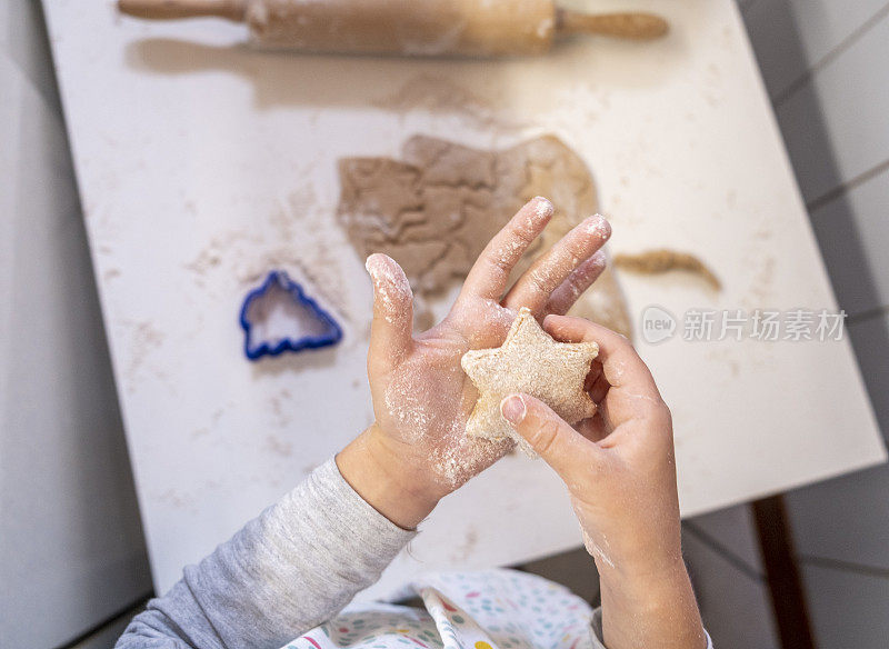 可爱的小手拿着一个星星形状的饼干特写