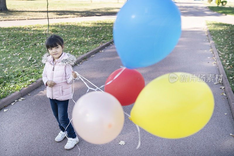 小女孩在公园里玩气球