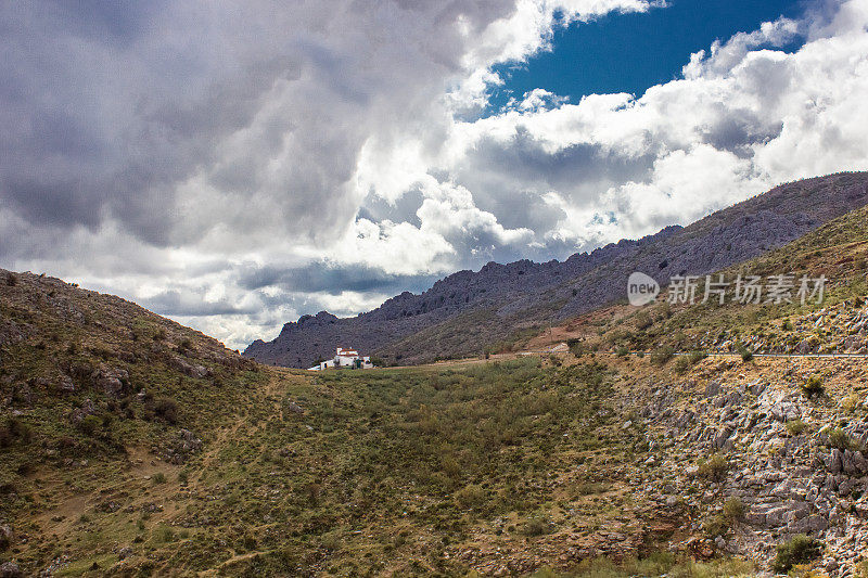 山景上的蓝色多云的天空背景。风景如画的群山在阳光下闪闪发光。令人屏息的自然影像