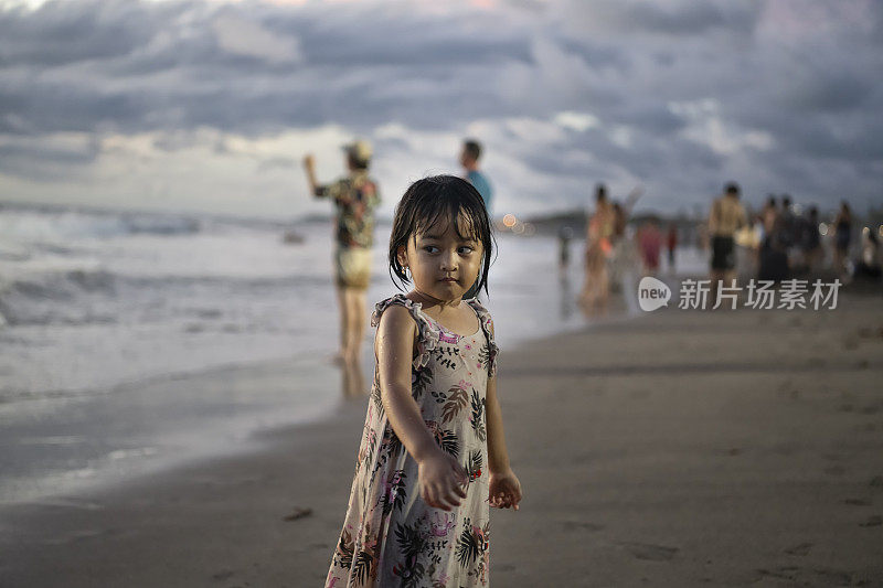 一个年轻的印尼孩子独自走在夕阳下的海滩上
