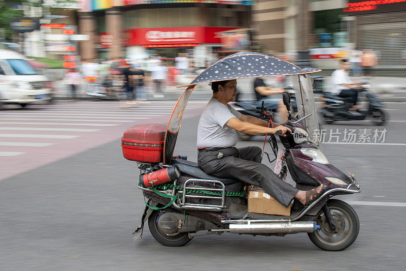 在重庆繁忙的街道上，一名男子骑着摩托车