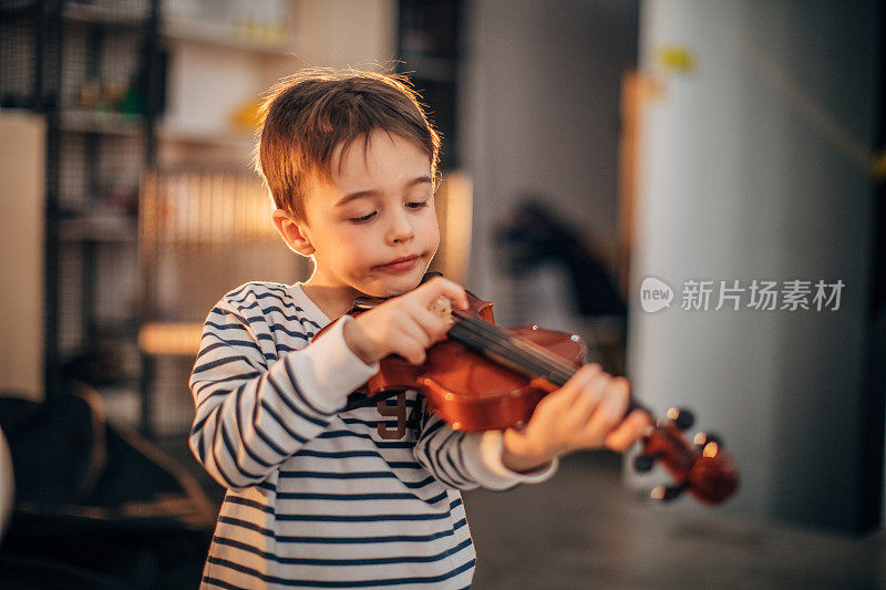 小男孩在教拉小提琴