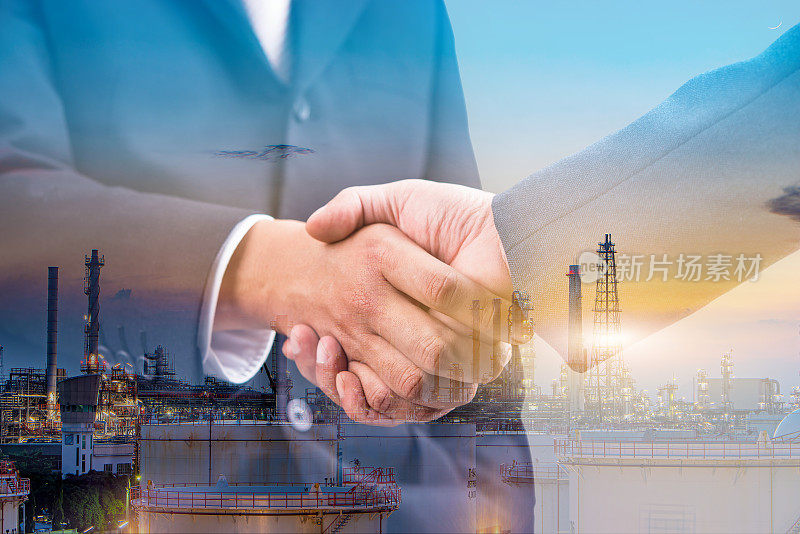 双曝光商业握手成功的投资交易和石油和天然气炼油厂在晚上，团队合作和伙伴关系的概念。