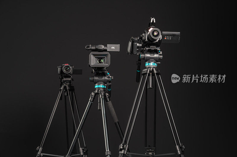 三种不同类型的视频电影摄影相机在黑色背景下，低角度观看