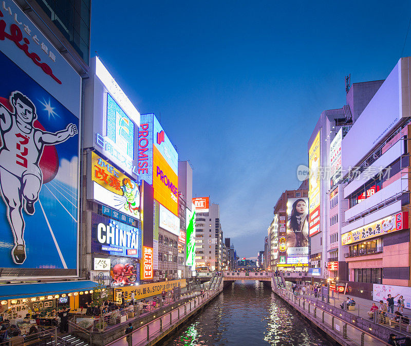 在日本大阪的道顿堀，五颜六色的广告牌照亮了大阪夜市周围的商店和零售店