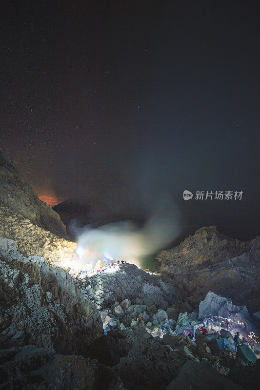 硫磺湖和冒烟的矿山山早上在卡瓦伊真火山印度尼西亚东爪哇与银河夜空的背景