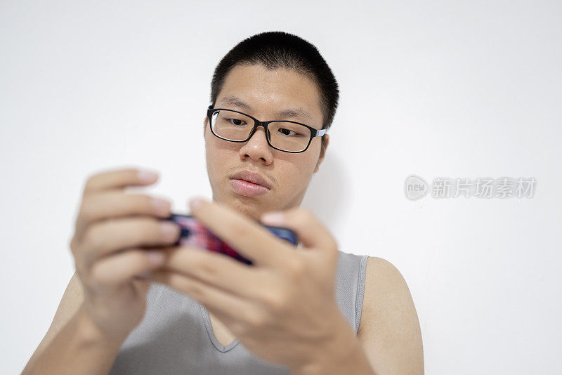 年轻的亚洲人低头使用手机