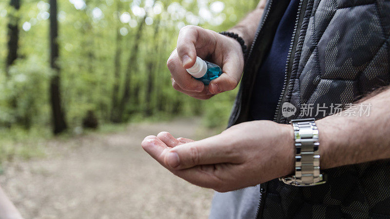 男士双手使用酒精消毒剂喷雾或抗菌喷雾