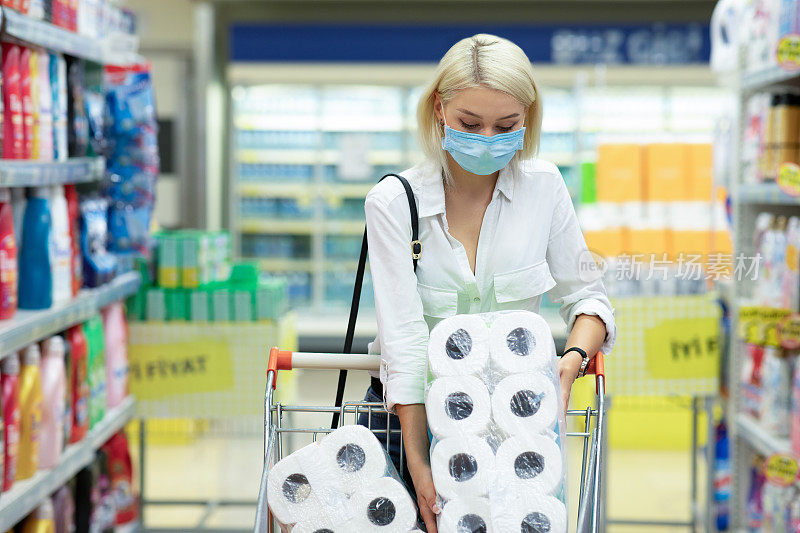 一名年轻女子在用品店惊慌失措地购买和拿着卫生纸