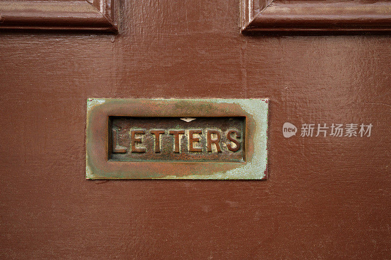 满是灰尘的旧棕色门细节和邮件槽