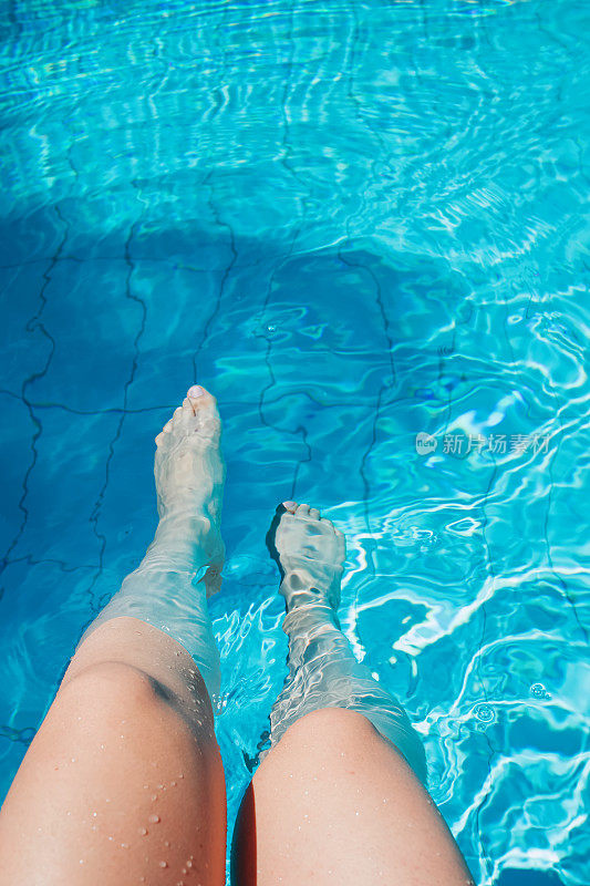 夏天，女人在游泳池里修腿