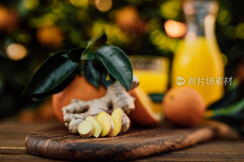 特写的切片生姜根和新鲜榨橙汁未经处理的生物橘子从自己的花园