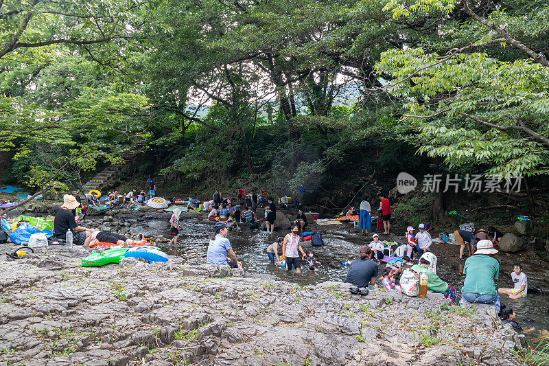 在炎热的夏天，许多人在凉爽的山谷水和树荫下享受暑假。