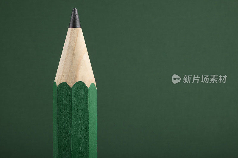 特写的削尖的铅笔孤立在绿色的背景