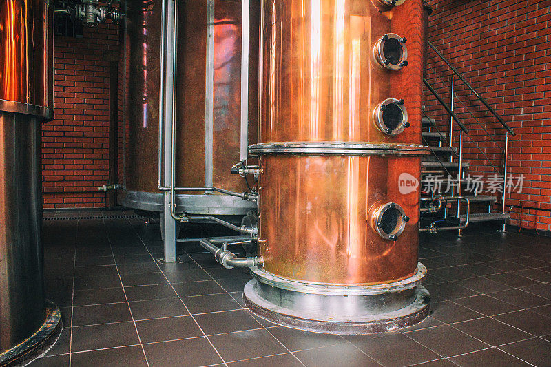 白兰地生产工业设备。铜在蒸馏器内蒸馏葡萄，产生烈酒。膜下噪声和大颗粒风格化。软焦点