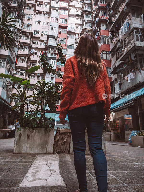 香港，一名女子抬头看着拥挤的公寓