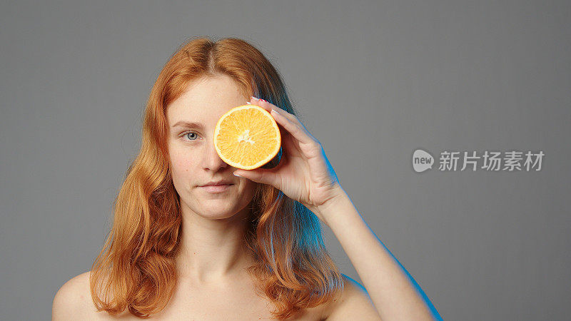 女人与橙色半孤立在灰色的copyspace
