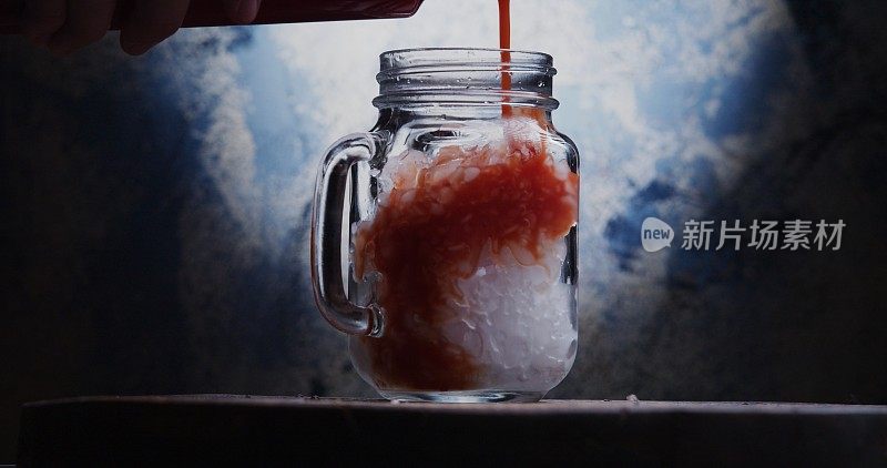 将番茄汁倒入盛满碎冰的玻璃瓶中