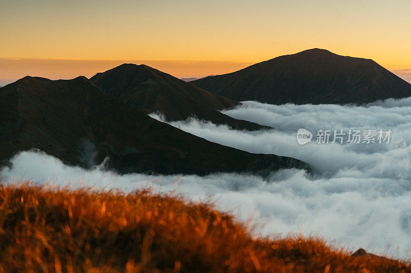 塔特拉山脉和日落的秋景。云朵飘浮于山峰之上