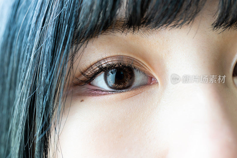 年轻的亚洲女人的眼睛，眼睛里戴着有色隐形眼镜