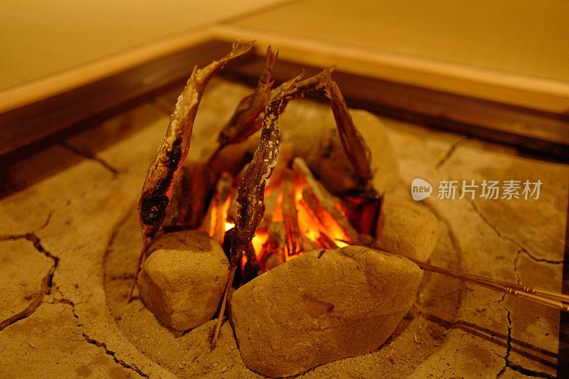 在irori壁炉的binchotan木炭火上烤着甜鱼