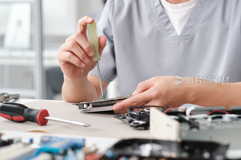 一名女性故障检修技师的手正在修理计算机硬件的微小细节