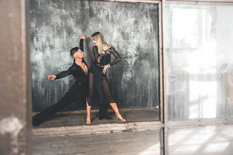 一对专业交谊舞舞者正在阁楼工作室跳舞。美丽的艺术表演。运动生活的概念。激情与情感的舞蹈。
