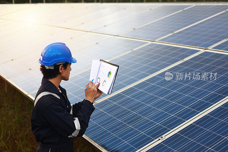 太阳能工程师佩戴安全PPE在太阳能农场工作，每天检查太阳能电池板，可再生和绿色能源的概念